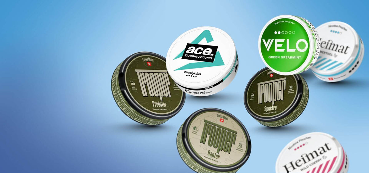 Odabir Snusa i Nicotine Pouches: Nоoper, Velo Green Spearmint i Heimat kutije na plavoj pozadini