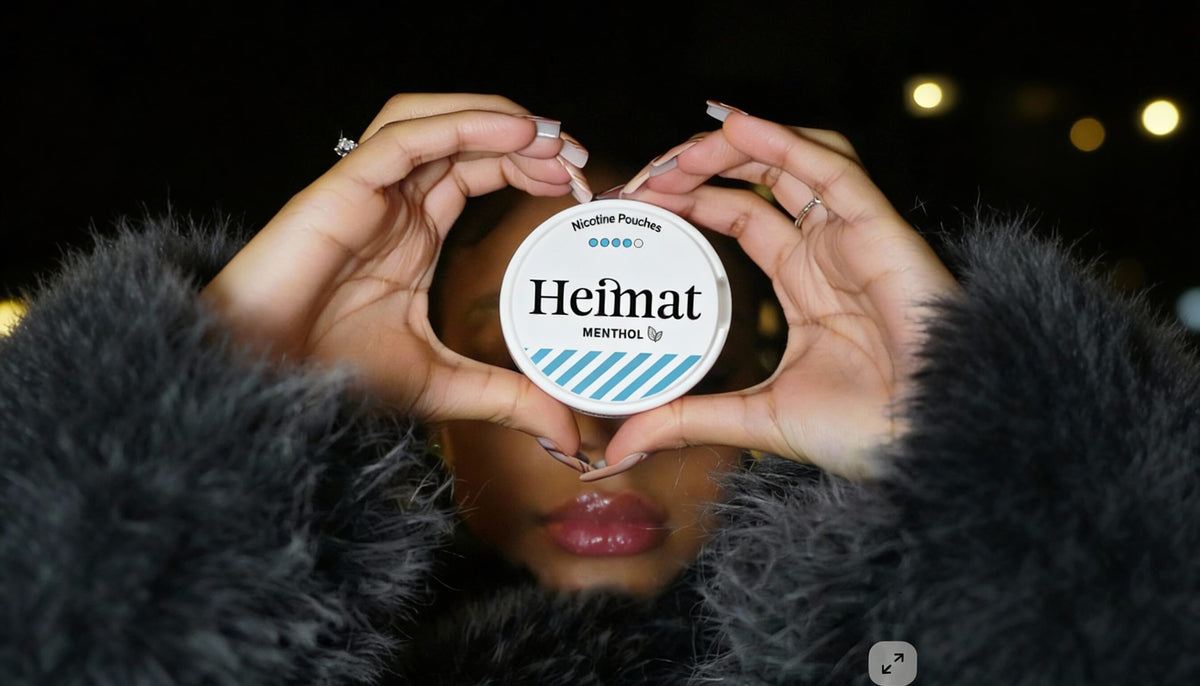 Heimat Menthol Nicotine Pouches Doza u obliku srca držana, Lifestyle fotografija žene u crnom kaputu
